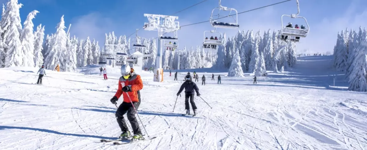 People enjoying skiing and snowboarding in mountain ski resort