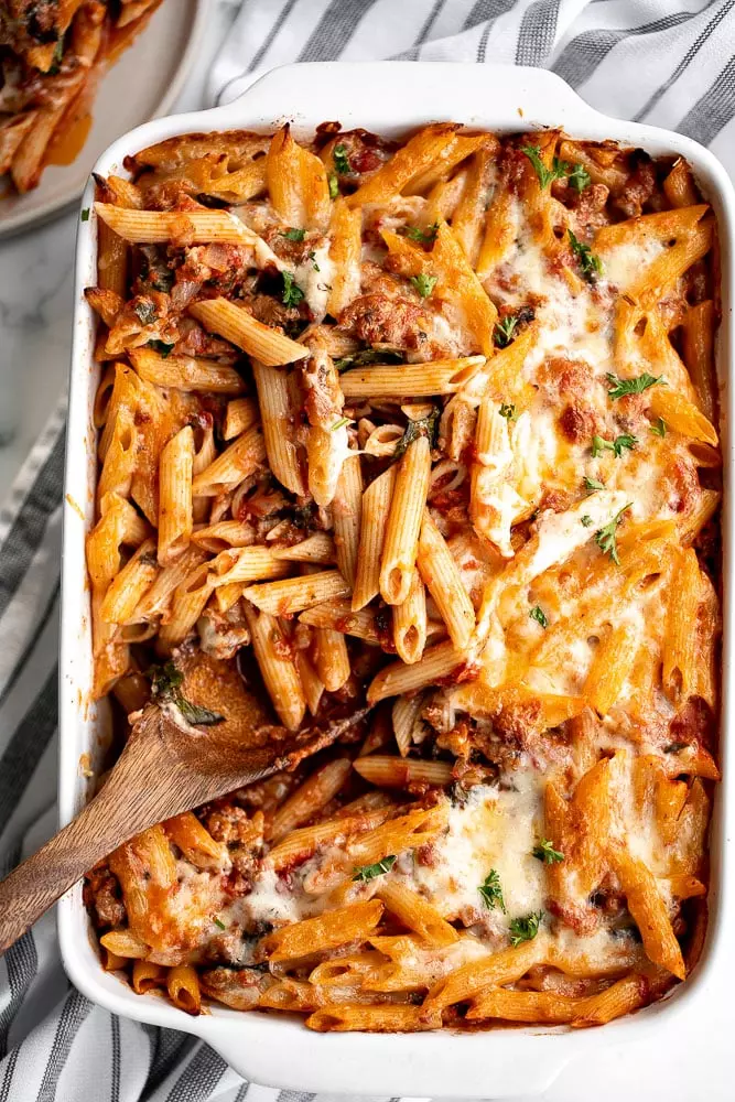 Pasta bake with sausage (baked ziti) is a lazy day lasagna with layers of pasta tossed in a rich meat sauce, layered with mozzarella, and baked.