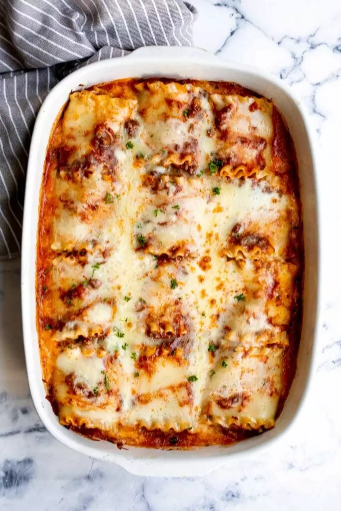 Lasagna roll ups are a twist on traditional lasagna. Lasagna noodles are filled with cheese and meat sauce and rolled up. Make ahead and freezer-friendly!