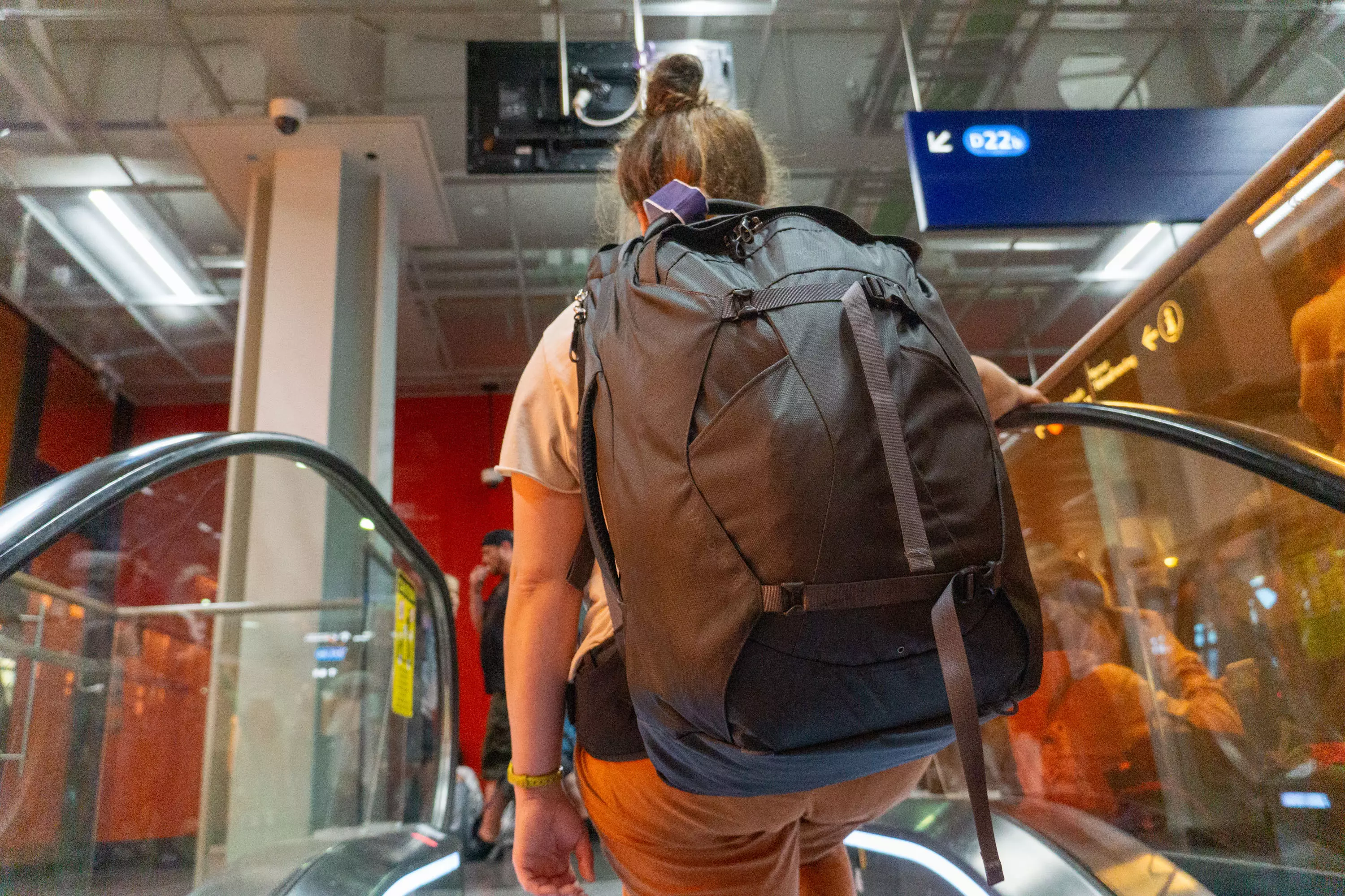 Peak Design Travel Backpack on the Back of a Traveller in Seattle International Airport Looking out on the Tarmac.
