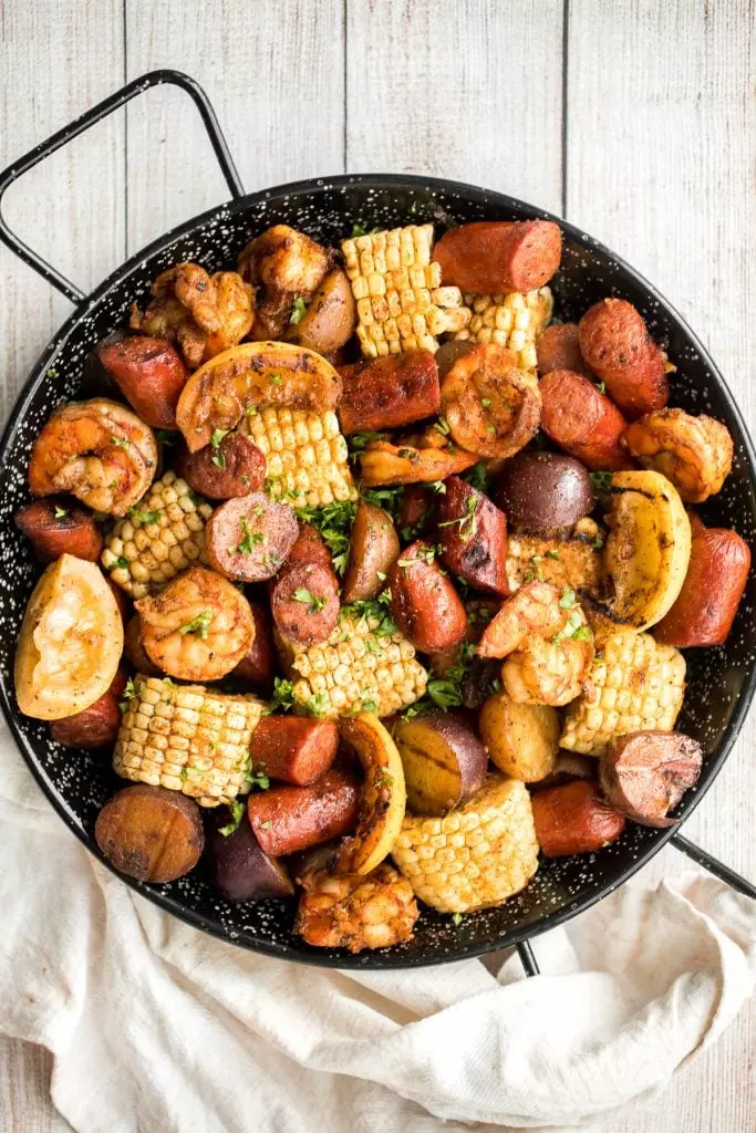 Easy, garlicky, and buttery grilled shrimp boil with prawns, corn, baby potatoes, and sausage, seasoned and tossed with parsley.