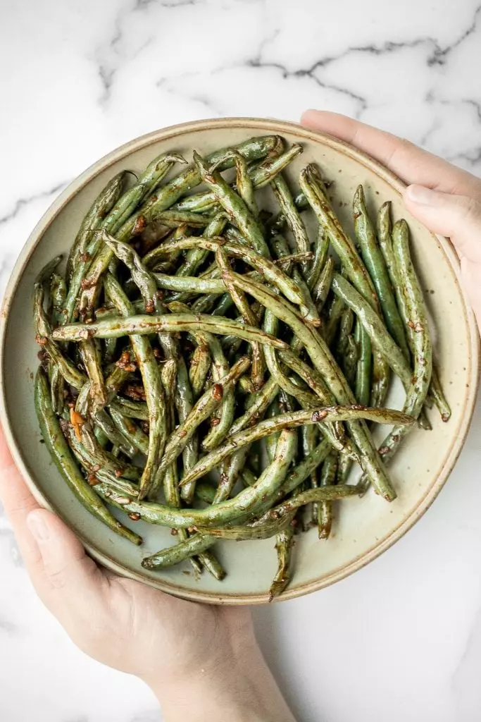 Quick easy roasted garlic green beans are tangy, sour, savory, and sweet, with a tender and crunchy texture. Make them in the oven or air fryer in minutes.