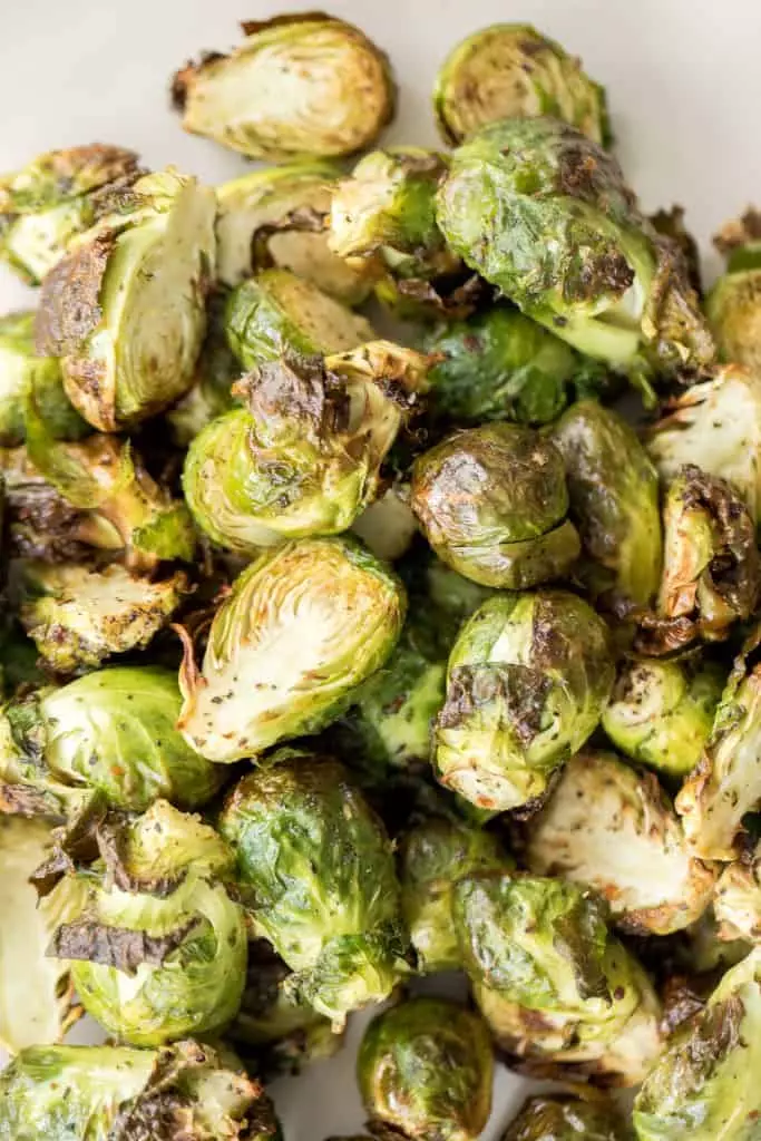 Tender and crispy roasted air fryer Brussels sprouts cook in less than 12 minutes with very little oil. They are a holiday table game changer.