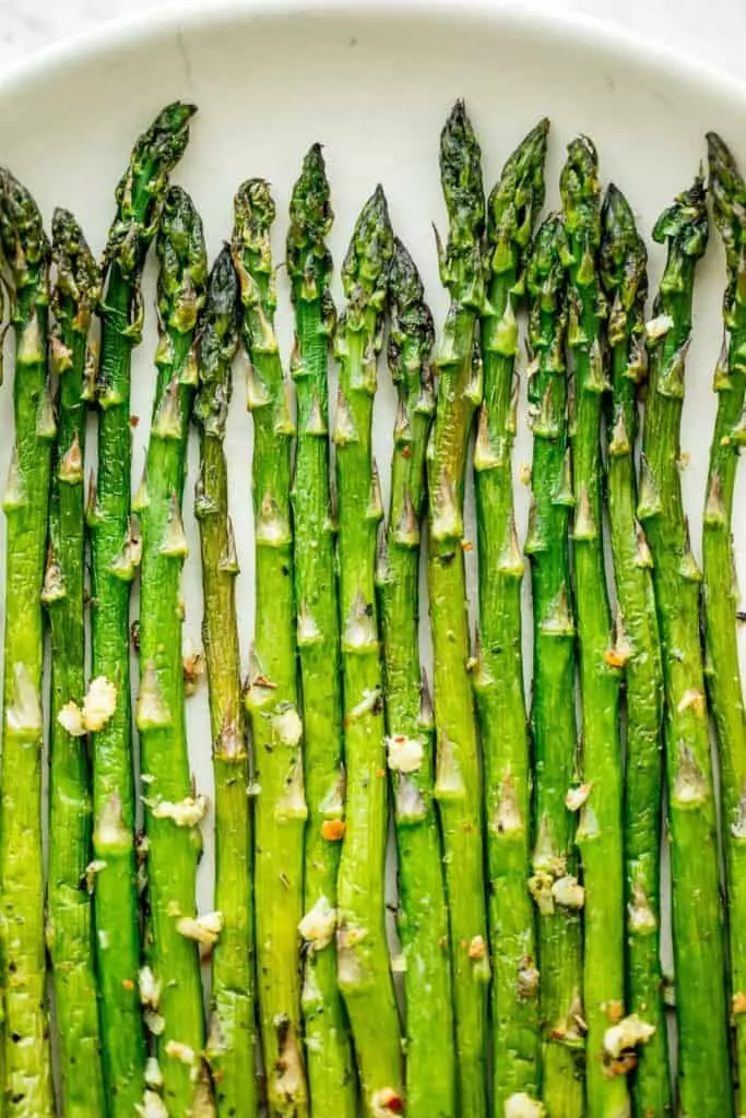 Crisp on the outside and tender on the inside, air fryer asparagus cooks in just 6 minutes! It is tossed in very little olive oil with garlic and seasonings.