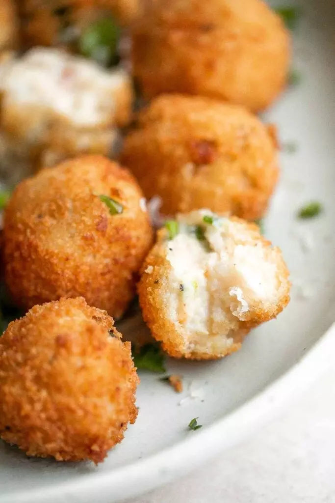 Mashed potato balls are a delicious appetizer that is crisp on the outside and soft, tender, and cheesy inside. The best way to use leftover mashed potatoes!
