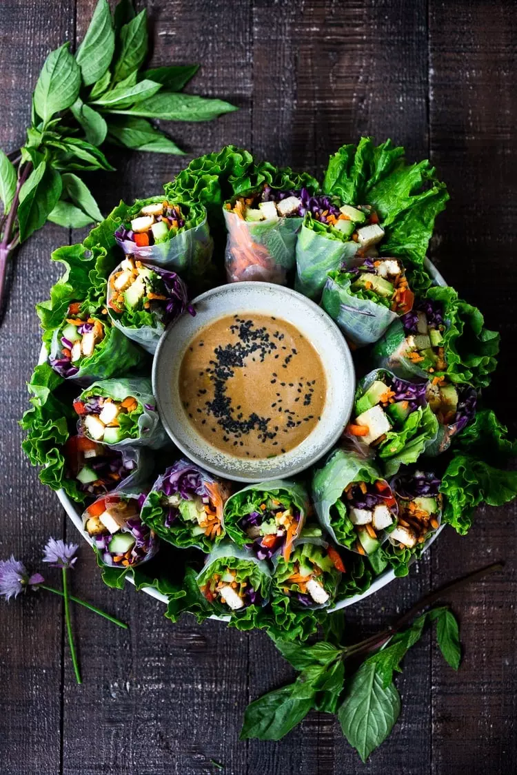 Fresh Spring Rolls with BEST EVER Peanut Sauce! These vegan spring rolls can be made ahead and are the perfect healthy appetizer for parties and gatherings! #springrolls #veganspringrolls #freshspringrolls #howtostorespringrolls #howtomakespringrolls #veganappetizer #appetizer