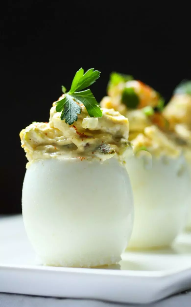 The Best EVER Deviled Eggs- Made with crumbled bacon (or vegan bacon bits), cheddar, and onion, simple and soooooo delicious! | #deviledeggs